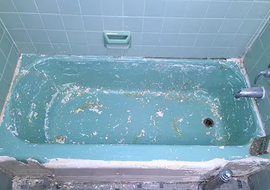 Damaged bathtub showing cracks and dull surface before reglazing
