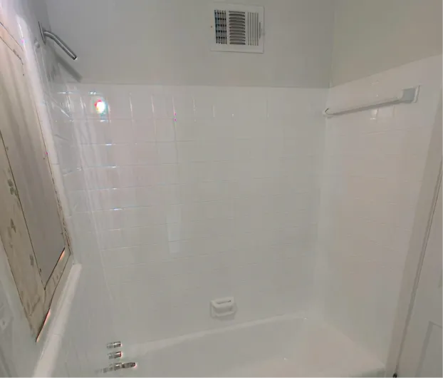 Like-new white bathtub and shower walls after professional resurfacing