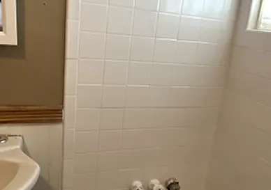 Old bathtub with peeling paint and discoloration before refinishing